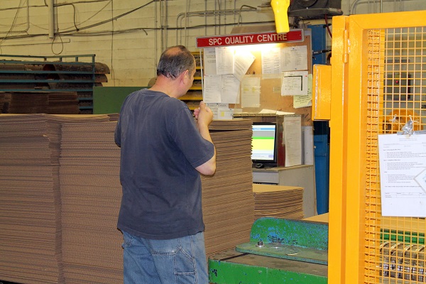 Man working at cardboard converting machine