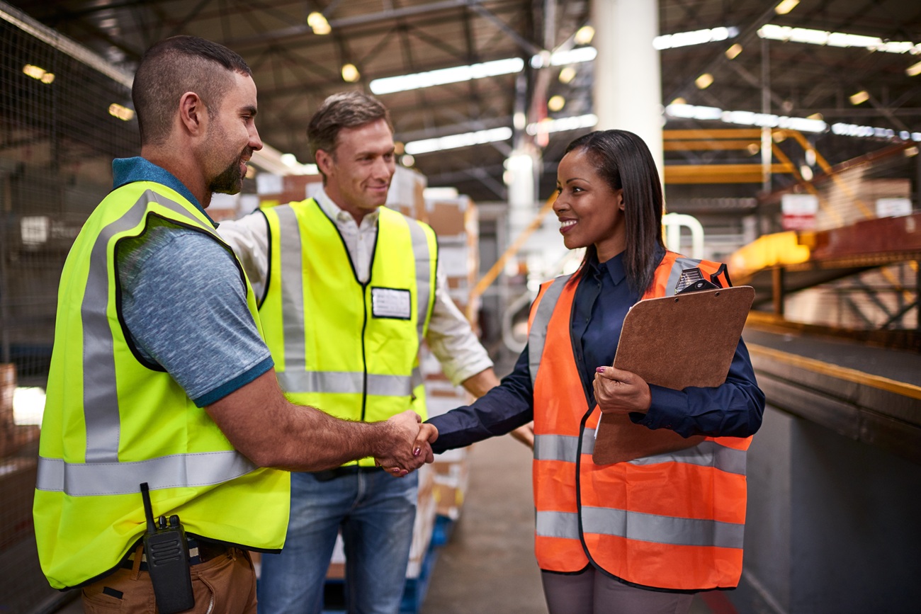 Workers shaking hands with inspector
