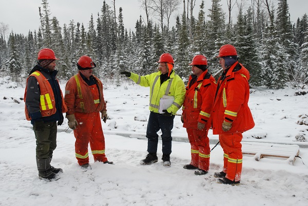 Group of workers standing outdoors in winter forest setting