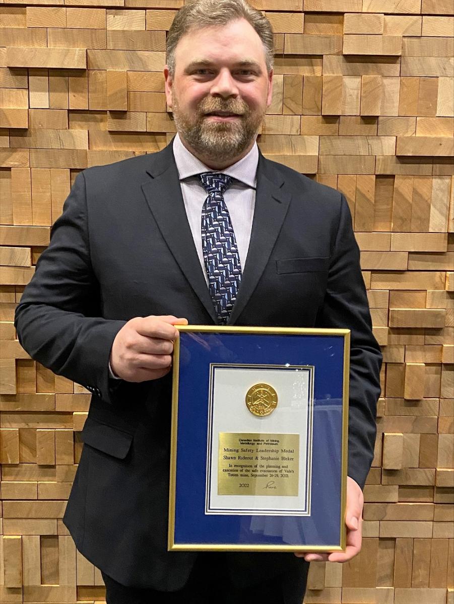 Man holding awards plaque